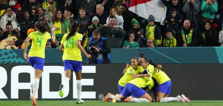 As meninas do futebol brasileiro se abraçando, uniformizadas